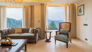 A living room with a sofa, chair, table, and a chandelier. - ELIVAAS privé Royce Cottage 4BHK Villa (Kasauli)