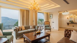 A spacious living room with a sofa, armchairs, a coffee table, and a chandelier. - ELIVAAS privé Royce Cottage 4BHK Villa (Kasauli)