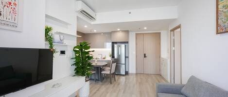 A modern apartment with a living area, kitchen, and dining space.