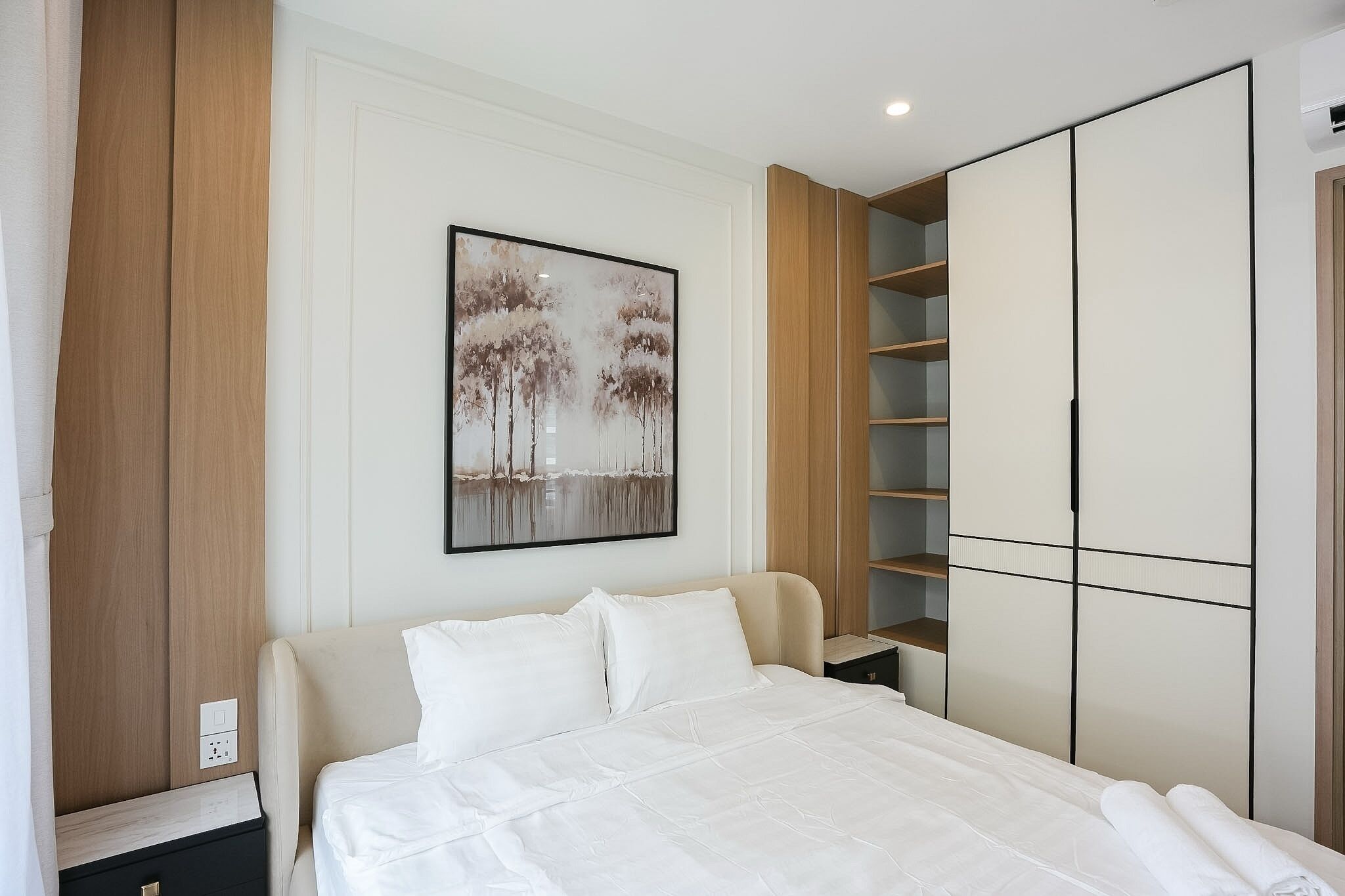 Un dormitorio con cama, armario y un cuadro en la pared.