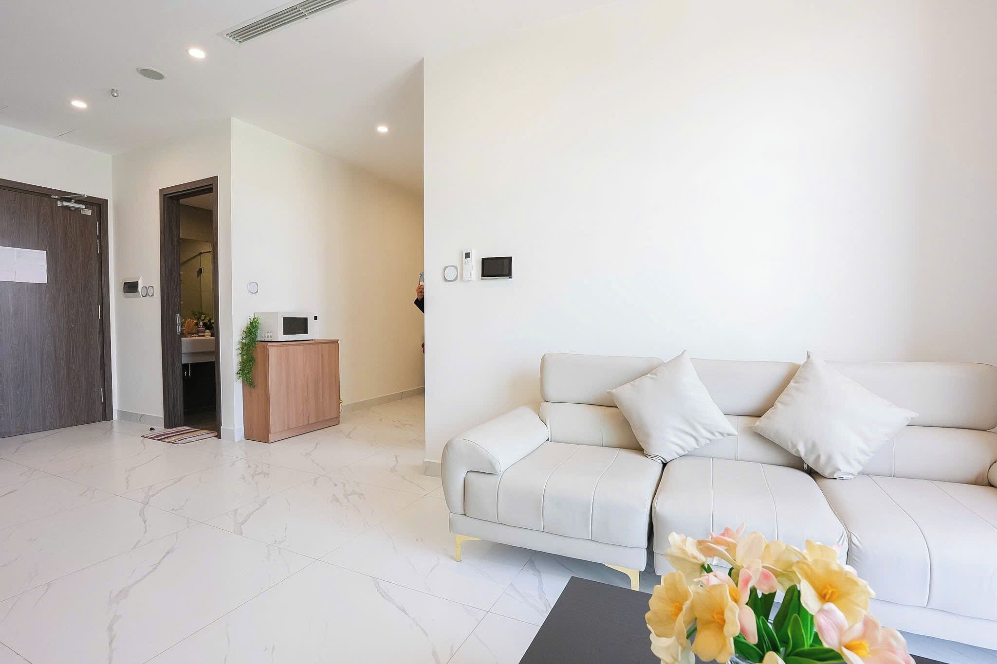 Una sala de estar moderna con un sofá blanco, una mesa de centro y un jarrón decorativo.
