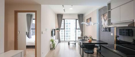 A modern kitchen with a dining area, a TV, and a view of the city.