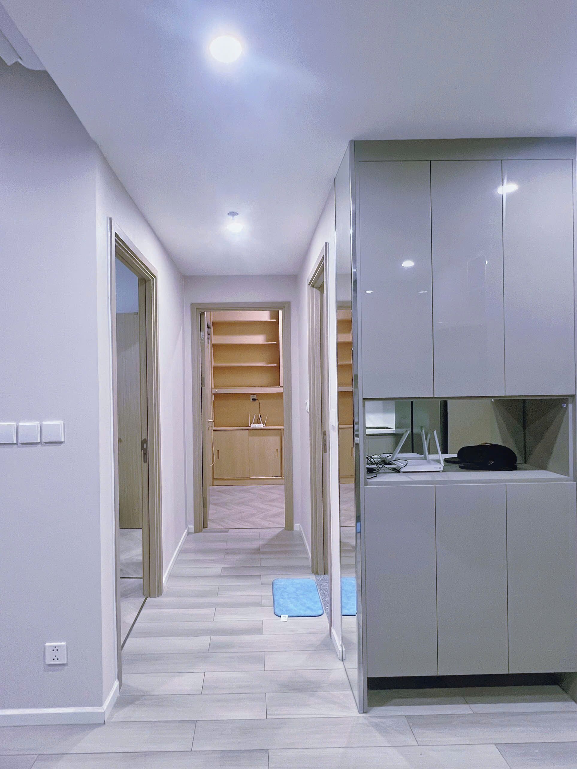 A hallway with a built-in desk, shelves, and a bench.