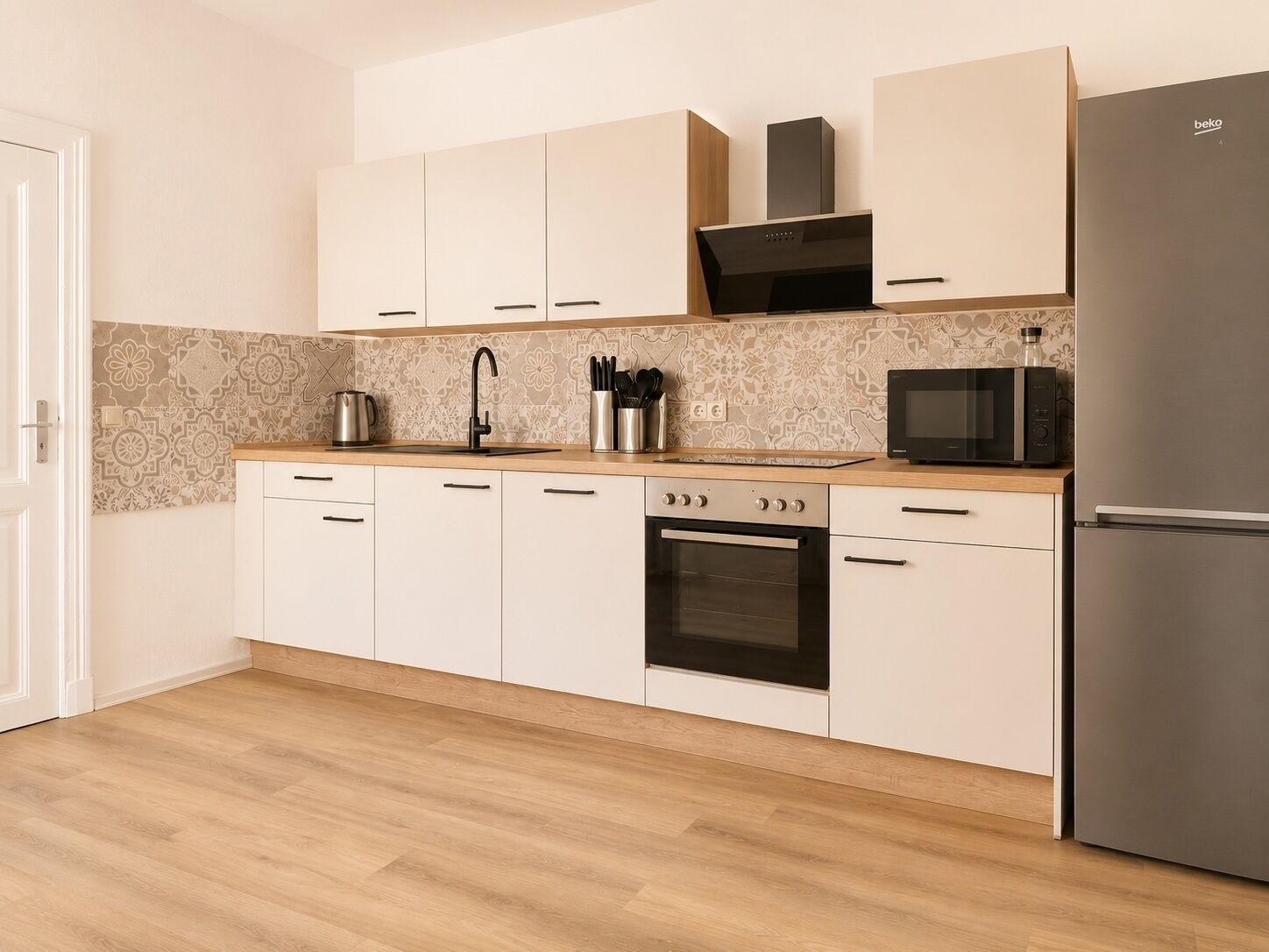 A kitchen with white cabinets, a stainless steel oven, a microwave, and a refrigerator.
