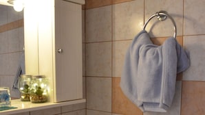 A bathroom with a sink, mirror, towel rack, and a shelf with jars. - DIAMOND VIEW (Lesvos)