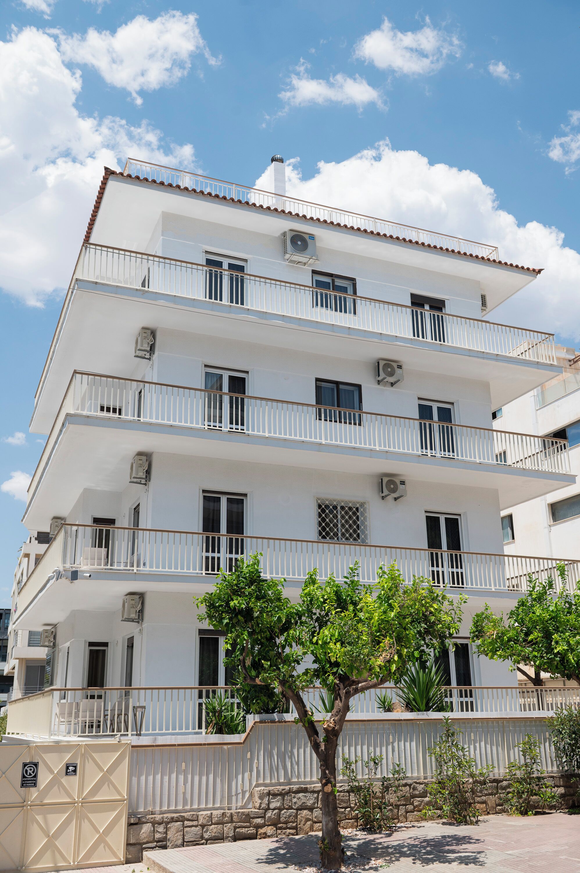 Un edificio a più piani con balconi, condizionatori d'aria e un ingresso carrabile.