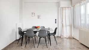 Een eethoek met een tafel, stoelen, een kom en een radiator.