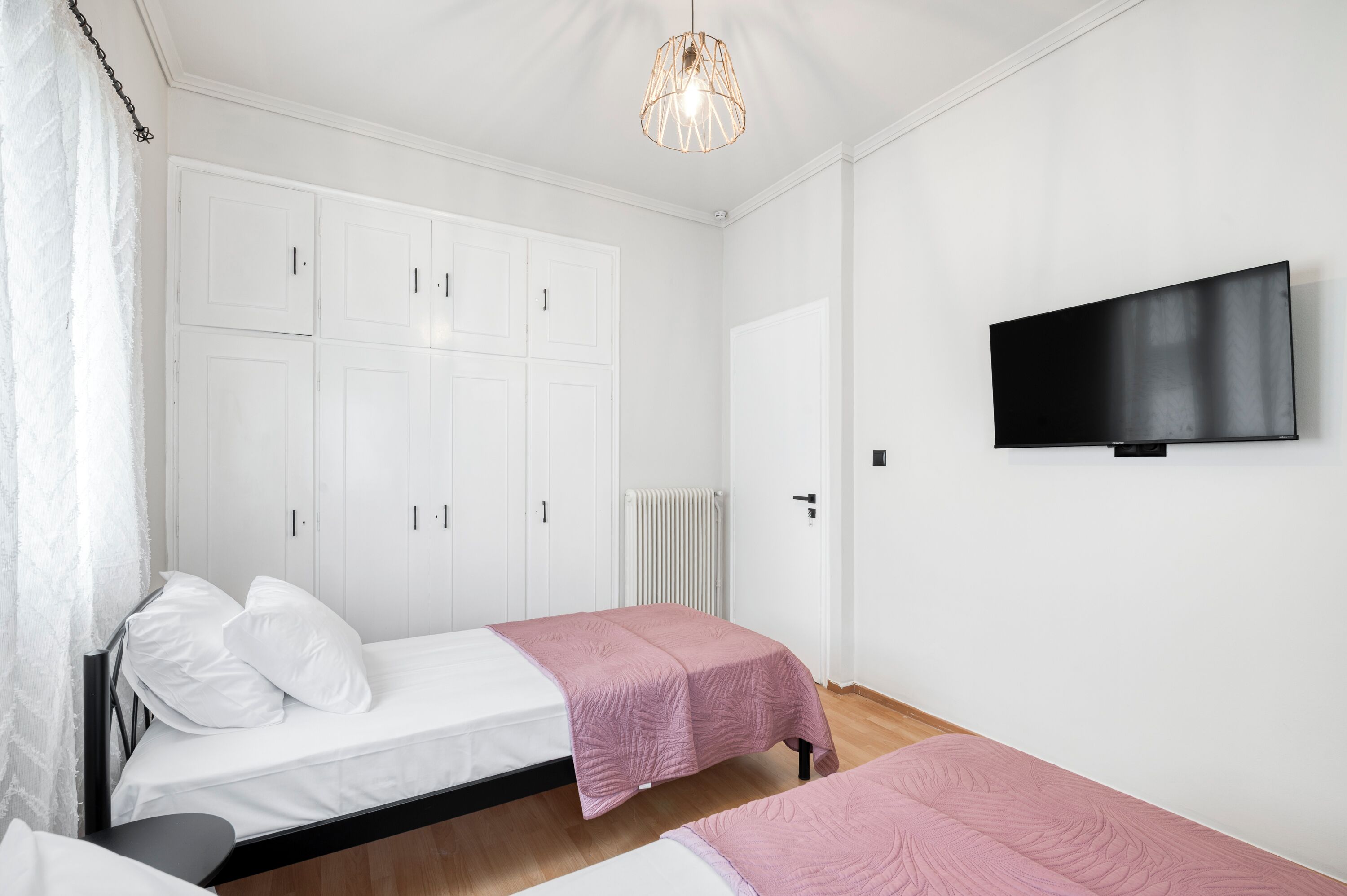 Ein Schlafzimmer mit zwei Betten, einem Fernseher und einem Kleiderschrank.