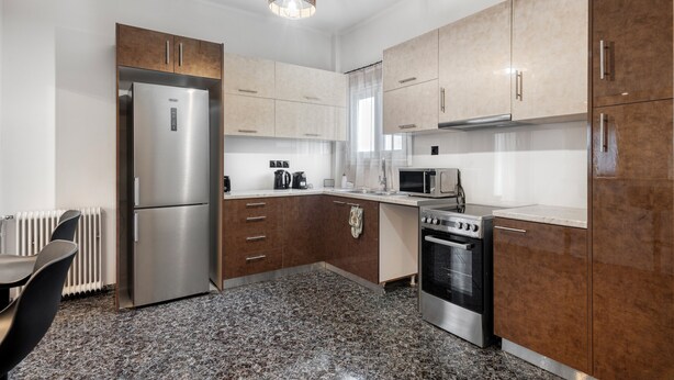 Een moderne keuken met roestvrijstalen apparatuur, houten kastjes en een granieten aanrecht.