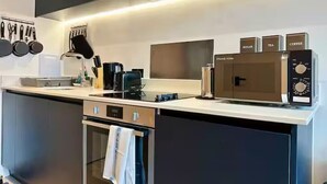Eine moderne Küche mit Einbauofen, Kaffeemaschine und Mikrowelle.