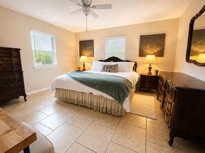 A bedroom with a bed, two bedside lamps, a ceiling fan, a dresser, and two windows with blinds. - Family-Friendly 4BR Getaway Close to Beaches, Fairhope & Fishing (Summerdale)