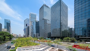 A modern urban landscape with high-rise buildings, a green park area, and a clear sky. - IntercityHotel Shenzhen Bay (Shenzhen)