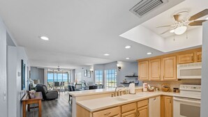 A modern kitchen with wooden cabinets, a white stove, and a large island with a sink.