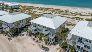 A beachfront hotel with multiple buildings, each featuring balconies and a beach view.