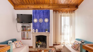 Ein Wohnzimmer mit Kamin, Fernseher und blauer Wand.