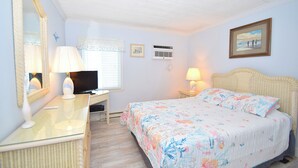 A bedroom with a bed, a desk with a lamp, a television, and a mirror. - Eldorado 2 - Ocean City, MD (Ocean City)