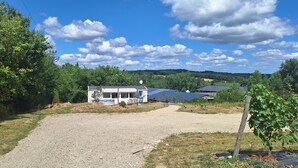 A house with a gravel driveway, solar panels, and a satellite dish. - Comfortable mobile homes (Bourgougnague)