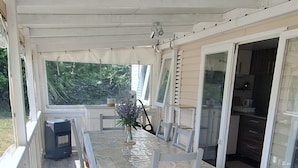 A covered patio with a table and chairs, a grill, and a view of the outdoors. - Comfortable mobile homes (Bourgougnague)