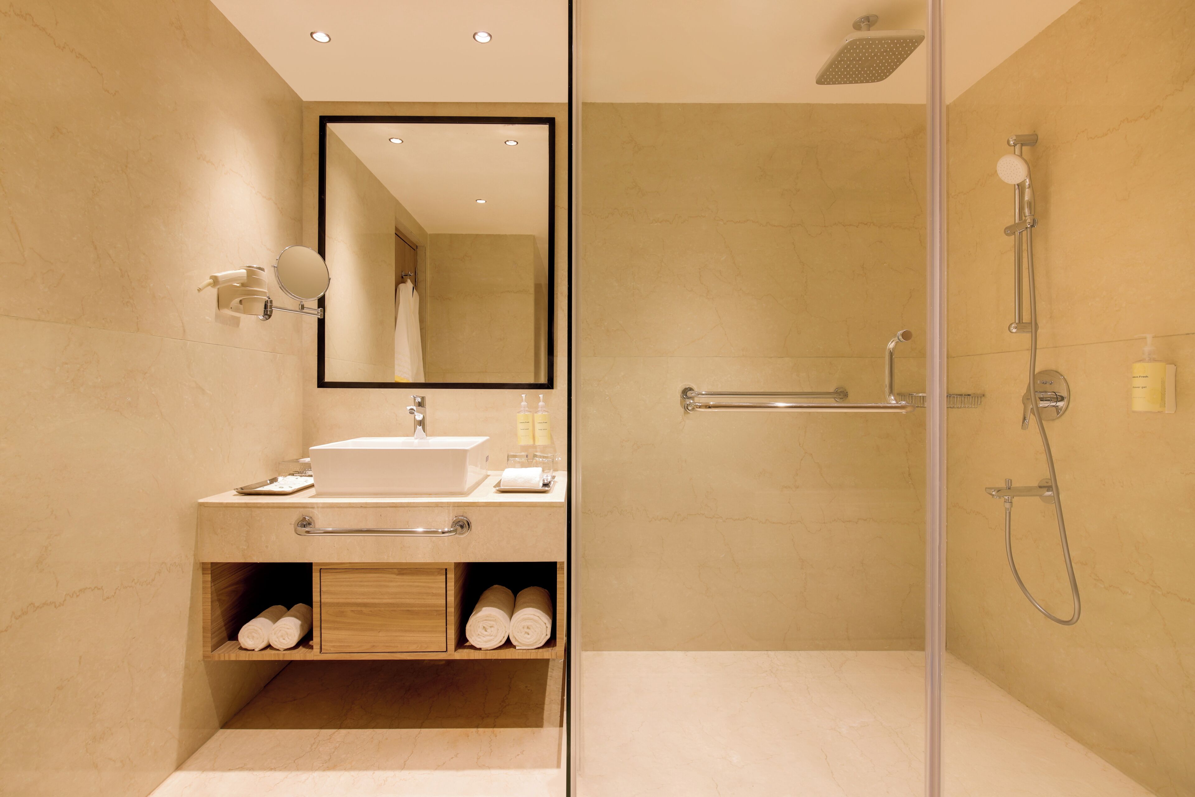 Un baño moderno con cabina de ducha de vidrio, lavamanos integrado y un espejo.