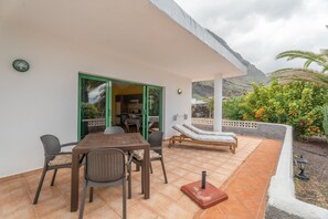 A patio with a table and chairs, a massage table, and a view of a mountain. - Apartment 'D' with Mountain View, Wi-Fi and Air Conditioning (Santa Cruz de Tenerife)