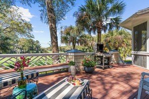An outdoor patio with a grill, seating, and a table with a fruit platter. - Incredible porches and easy beach access (Kiawah Island)