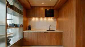 Una cocina moderna con armarios de madera, encimera de mármol y horno empotrado.