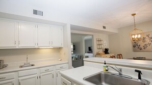 A modern kitchen with white cabinetry, stainless steel sink, and a pendant light. - 3-Bedroom Pinehurst Condo at Lakeview with Pool (Pinehurst)