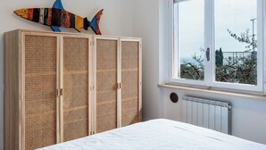 Un dormitorio con cama, ventana con vistas y armario decorado con un pez.