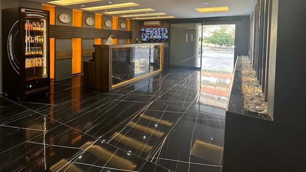 A modern lobby with a reception desk, a digital clock, and a vending machine. - LOCA MARİN OTEL (Kocasinan)