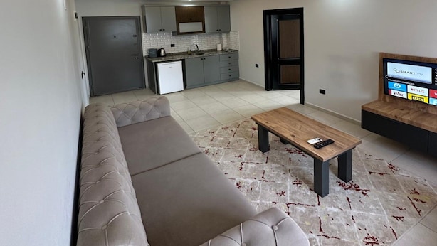 Uma sala de estar moderna com um sofá, uma mesa de centro e uma televisão.