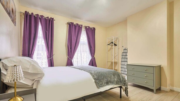 A bedroom with a bed, a bedside lamp, a dresser, and a wardrobe. - Host Stay Dover Retreat (Ipswich)