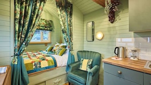 A room with a bed, a chair, a small table with a kettle, and a cabinet. - Host Stay Curlews Rest (Preston)