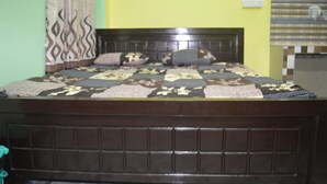 A bed with a dark headboard, patterned bedding, and pillows.