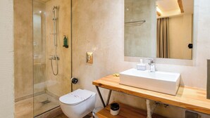 Ein modernes Badezimmer mit einer Duschkabine, einer weißen Toilette und einem Holzlagerfläschchen mit Waschbecken.