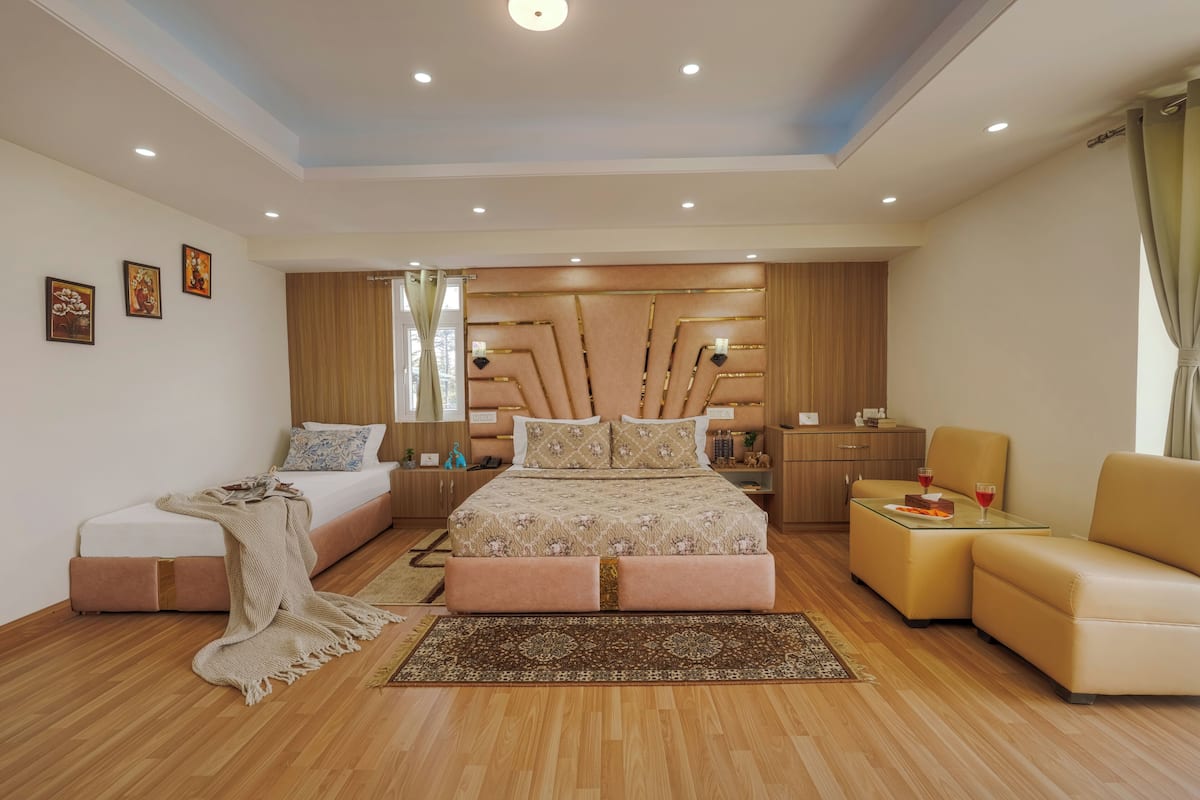 A modern bedroom with a bed, sofa, and a small table with drinks.