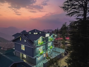 Un edificio de varios pisos con balcones y vistas del paisaje circundante.