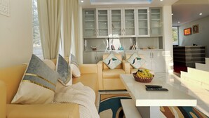 Ein modernes Wohnzimmer mit einer Couch, einem Couchtisch und einer Küchenzeile mit Schränken.