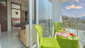 Ein Balkon mit Schachbrett, zwei Stühlen und zwei Getränken.