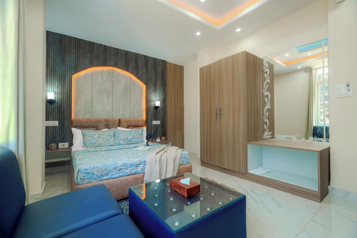 A modern bedroom with a bed, a glass coffee table, a wardrobe, and a vanity with a mirror.