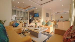 Ein modernes Wohnzimmer mit Sofas, einem Couchtisch und einem Fernseher.