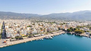 A coastal cityscape with a marina, buildings, and mountains in the background. - Panellinion Beachfront Gem, Comfy & Sunny Triple (Kalamata)