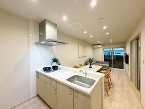 Eine moderne Küche mit Einbauherd, Spüle und Essbereich mit Tisch und Stühlen.
