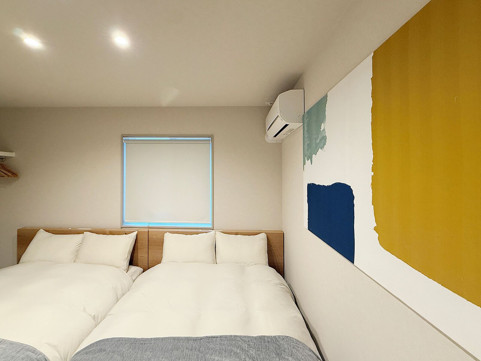 Une chambre à coucher avec un lit, une fenêtre et un appareil de climatisation.