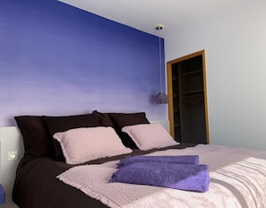 A bedroom with a bed, pillows, a blanket, a hanging light fixture, and a wardrobe. - Quiet Lucia sheepfold, private heated pool (Figari)