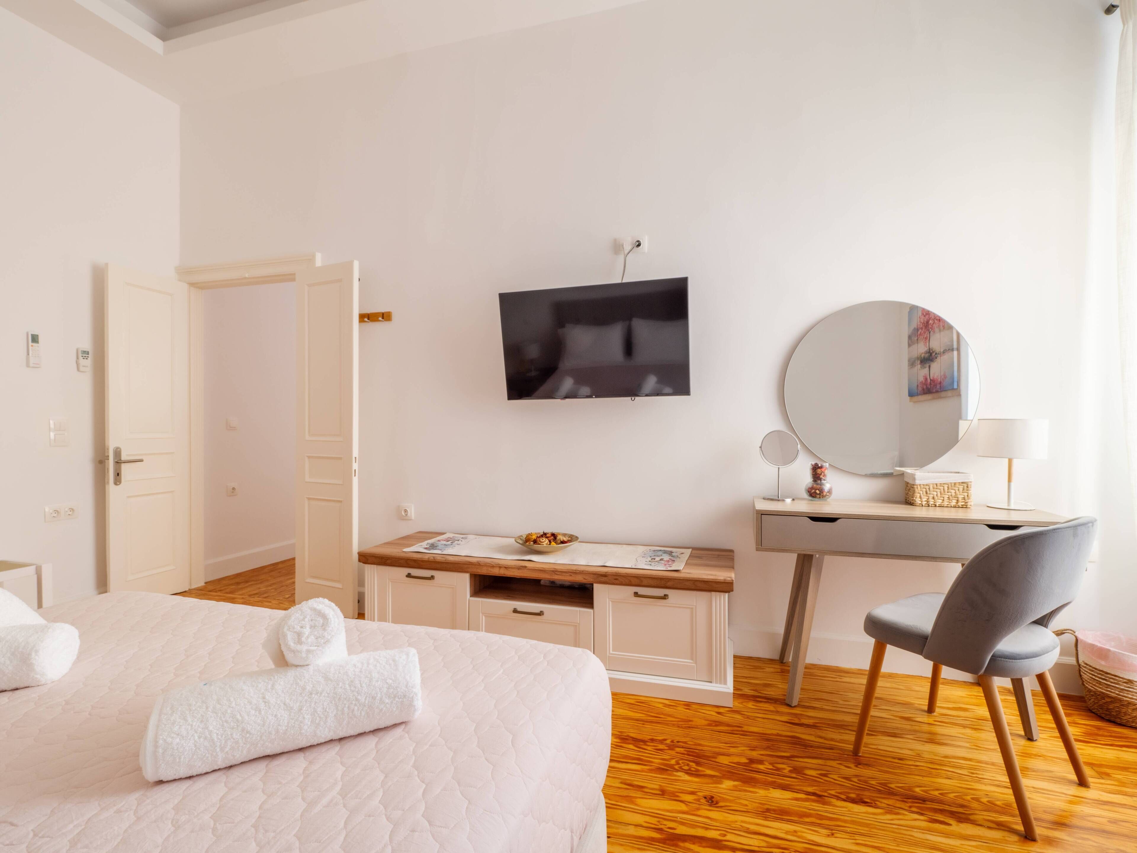 Une chambre d’hôtel comprenant un lit, un bureau avec un miroir, une télévision et une chaise.