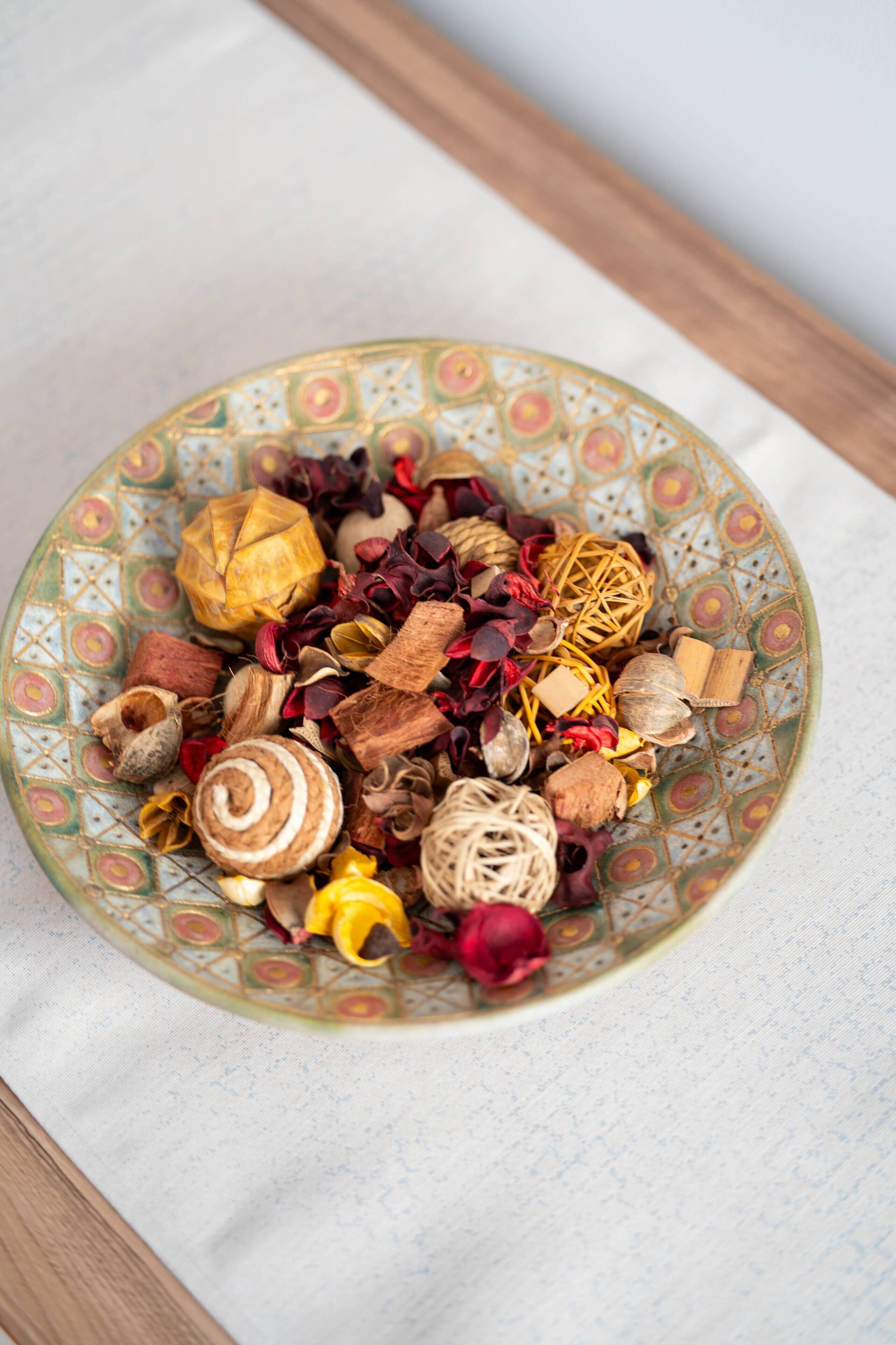 A bowl filled with various dried flowers and herbs.