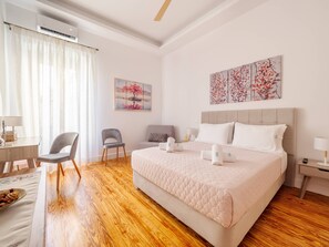 A hotel room with a bed, a desk, a chair, and a nightstand. - Alexandras Luxury Heaven (Corfu)