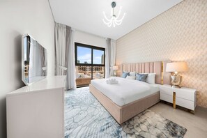 A modern hotel room with a large bed, a nightstand, a mirror, and a view of the city. - Free Housekeeping Visits During Your Stay - Stayshort - Modern 3 Bedroom Duplex Apartment in JVC That Sleeps 5 (Dubai)