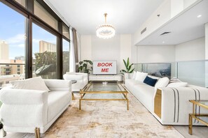 Ein modernes Wohnzimmer mit einer Couch, einem Couchtisch und einem Schild mit der Aufschrift 'BOOK ME'.