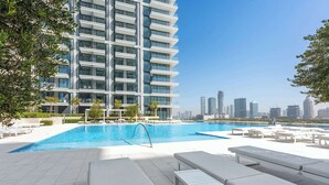 A modern building with a pool and lounge area. - Free Housekeeping Visits During Your Stay - Stayshort - Relaxing 1 Bed That Sleeps 4 With Amazing Views From Balcony (Dubai)